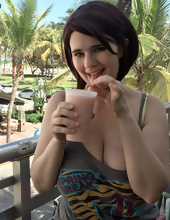 Big-tittied girl takes pictures on the beach and in the cafe